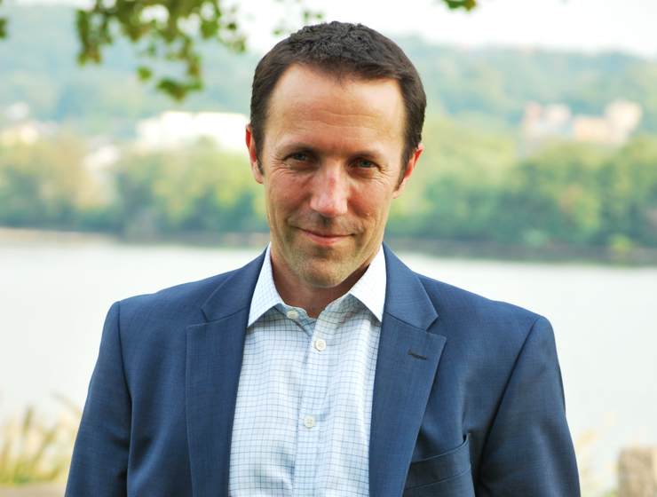 casual headshot of a man standing in the park