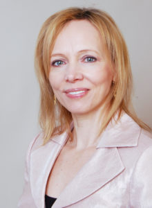 corporate headshot of a female real estate agent from christie's in a classy light pink jacket smiling