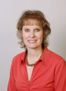 headshot of a healthcare professional in business casual red shirt and smile