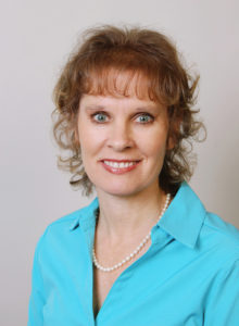 professional headshot of a healthcare professional in business casual bright blue shirt
