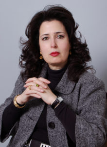 business headshot of an interior designer in dark grey jacket and black sweater