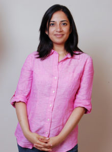 picture of an indian lady standing in blue jeans and pink shirt