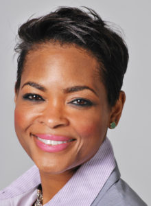 corporate headshot of a female executive in suit smiling