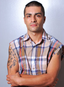 headshot of a break dancer in checkered sleeveless shirt