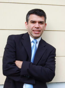 picture of a handsome hispanic man wearing a suit and looking at the camera