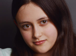 close-up headshot of a child actress in dc leaning her head