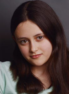 headshot of a child actress leaning her head in a quiet mood