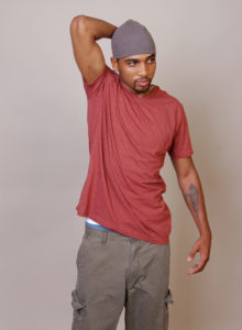 picture of a black male model with a burgundy shirt and cargo pants standing