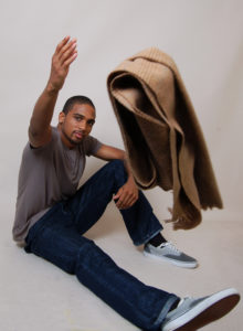 picture of a young black model tossing a scarf at the camera