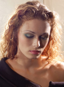 headshot of a blonde model with curly hair and lighting effects