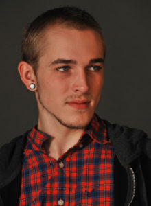 headshot of a male model in red shirt looking away