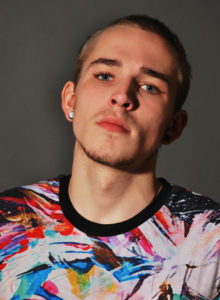 headshot of a male model in multicolored shirt leaning his head
