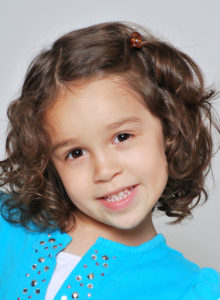sample headshot of a child actor playfully tilting her head