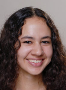 actor's headshots ideas: female teen drama actor with curly hair and a big smile