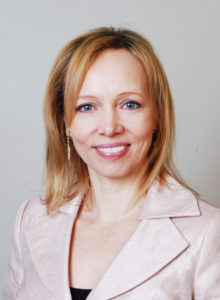 headshot of a female corporate realtor from christie's in a classy pose looking at the camera smiling