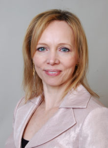realtor headshot of a female agent from christie's in a classy light pink jacket looking at the camera