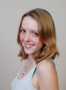 headshot of a teen model in tank top 3/4 profile smiling
