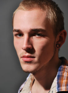 headshot of a young aspiring model 3/4 profile in dramatic light