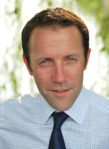 casual business headshot of man with shirt and tie looking at the camera