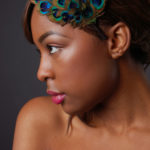 beauty shot of a model with makeup and colorful feathers on her hair for model portfolio