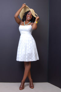 picture of a promotional model wearing a white lace dress holding a large brim hat