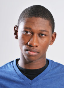 actor head shot of a teen in dc wearing a blue t-shirt thinking
