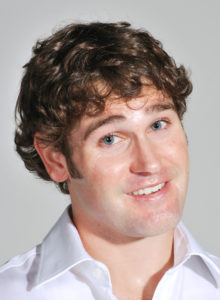 acting headshot of a man with white shirt with his head tilted and a curious look